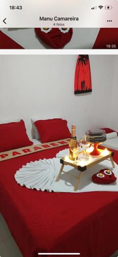 a red and white bed with a table on it at Pousada in Porto De Galinhas