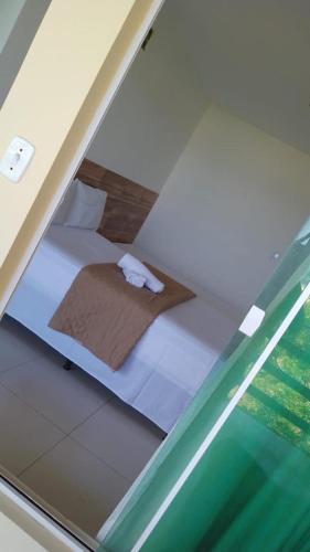 a small bed in a room with a glass window at Pousada in Porto De Galinhas