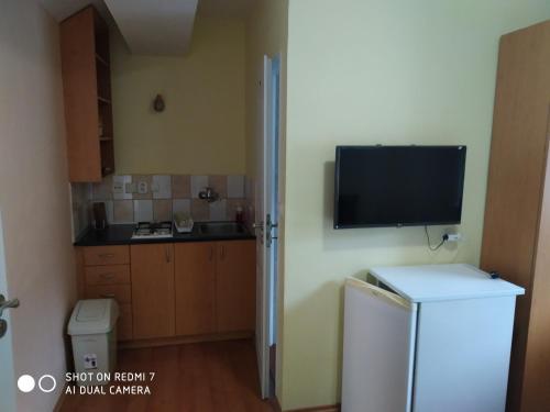 a kitchen with a refrigerator and a tv on the wall at Chalupa Synka in Terchová