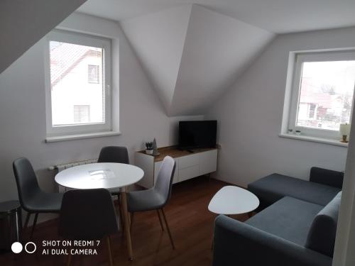 a living room with a couch and a table and chairs at Chalupa Synka in Terchová