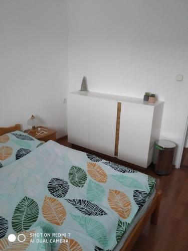 a bedroom with two beds and a white wall at Chalupa Synka in Terchová