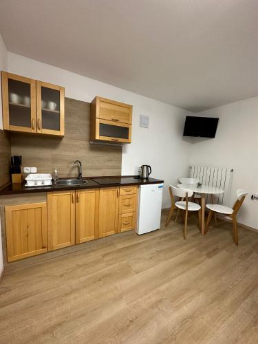 a kitchen with a sink and a table with a chair at Chalupa Synka in Terchová