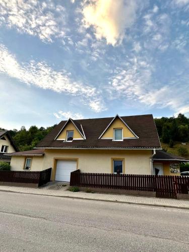 a house with a brown roof and a fence at Chalupa Synka in Terchová
