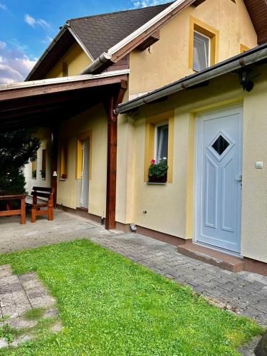a house with a blue door and a yard at Chalupa Synka in Terchová