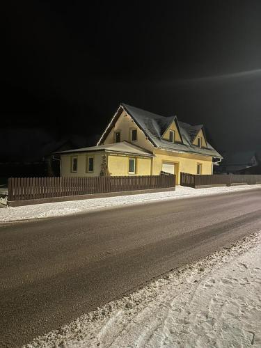 a yellow house on the side of a road at Chalupa Synka in Terchová