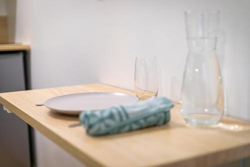 a table with a plate and two glasses on it at Nid Calme en Hypercentre - Proche Métro & Gare in Toulouse