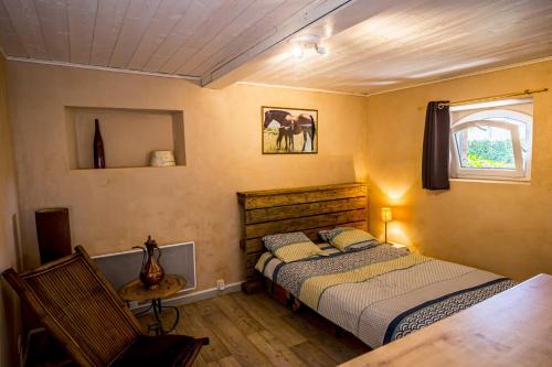 a bedroom with a bed and a chair and a window at Appartement Le Licol in Petite Sainte-Anne