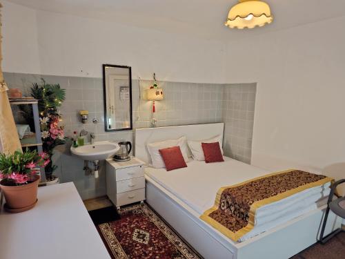 a bedroom with a white bed and a sink and a sink at China-Ferienzimmer in Berchtesgaden