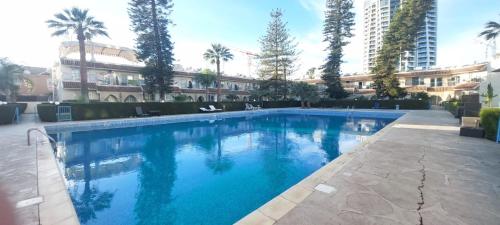 a large blue swimming pool in front of a building at Palm Beach Apartment 26 in Limassol