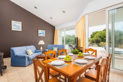 a living room with a table and chairs and a couch at Villa Elena Dorada in Port d'Addaia