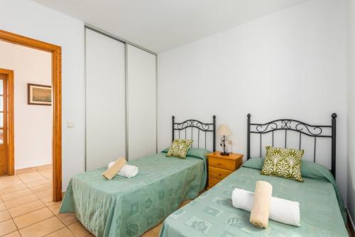 a bedroom with two twin beds and a mirror at Villa Elena Dorada in Port d'Addaia