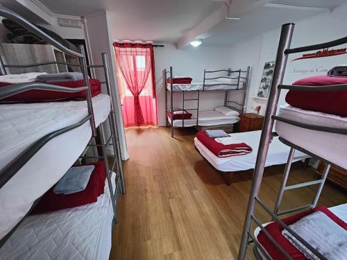 a room with several bunk beds in a dorm at Albergue Vintecatro in Caldas de Reis