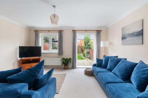 a living room with blue couches and a tv at Redhill,Sleeps9,Parking,17minsLGW30 to London in Merstham
