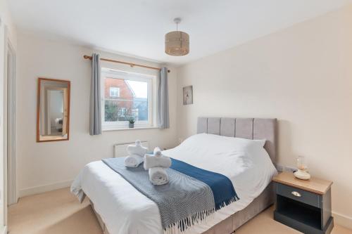 a bedroom with a bed with towels on it at Redhill,Sleeps9,Parking,17minsLGW30 to London in Merstham
