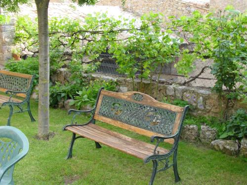 two benches in a garden with a stone wall at Casa Rural Cal Farragetes in Tuixen