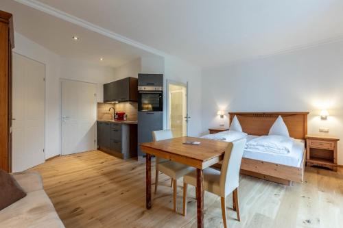 a bedroom with a bed and a table and a kitchen at Apartments am Schloss Mühldorf in Feldkirchen an der Donau