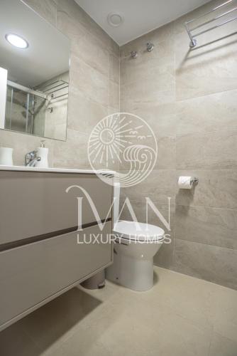 a bathroom with a toilet and a sink and a mirror at Casa Munteanu Ivan Luxury Homes 6ªPlta Norte 1ªLinea in Oropesa del Mar