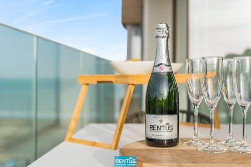 a bottle of wine sitting on a table with wine glasses at Sol i Mar - located in the heart of Westende in Middelkerke