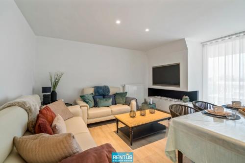 a living room with a couch and a table at Sol i Mar - located in the heart of Westende in Middelkerke