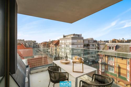 a balcony with a table and chairs and a view of the city at Sol i Mar - located in the heart of Westende in Middelkerke