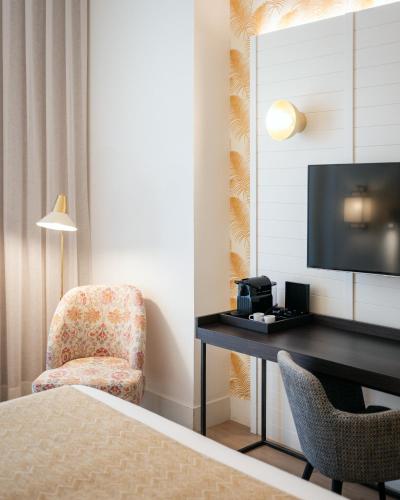 a hotel room with a bed and a desk and a chair at Molina Lario in Málaga