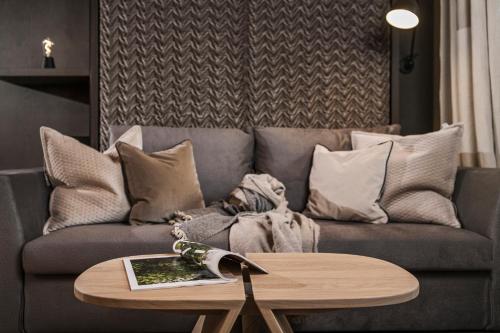 a living room with a couch and a wooden table at Villa Haidacher Relax & Lifestyle Apartments in Zell am Ziller