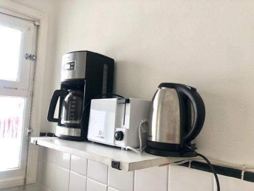 ein Regal mit drei Mikrowellen und einer Mikrowelle in der Unterkunft Departamento zona Güemes, a dos cuadras del mar ,Dos ambientes,céntrico in Mar del Plata