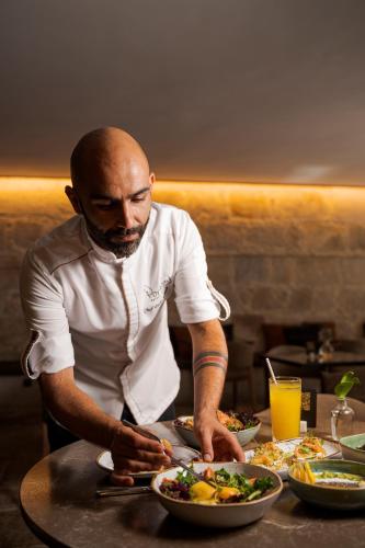 a man preparing a plate of food on a table at PortoBay Flores in Porto