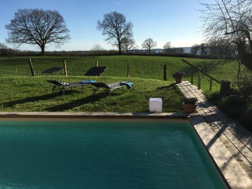 a swimming pool with a picnic table and a field at Hoheluft am Wittensee Apt 1 in Groß Wittensee