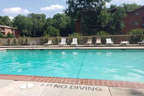 a large blue swimming pool with chairs and a fence at Walkable to Sanford Stadium or downtown in Athens