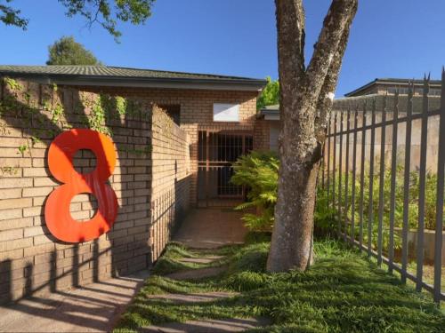 a building with a fence with a number on it at Forest and Ferns in Graskop
