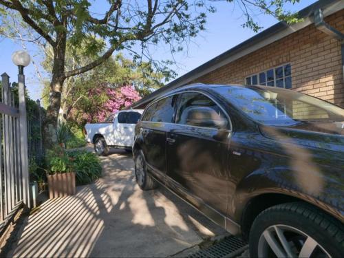a black car parked in front of a house at Forest and Ferns in Graskop