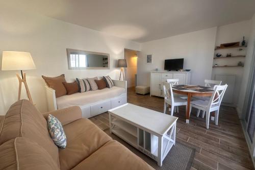 un salon avec un canapé et une table dans l'établissement Côté Mer - Appartement vue mer en première ligne, au Grau-du-Roi