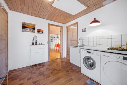 a kitchen with a washer and dryer in a room at Lovely Holiday House With 4 Rooms Close To The North Sea in Frøstrup