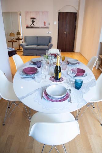 a white table with plates and wine glasses on it at Il Cenacolo Milano Centro Cadorna Santambrogio comodo per Fiera e Allianz Milano Convention Centre in Milan