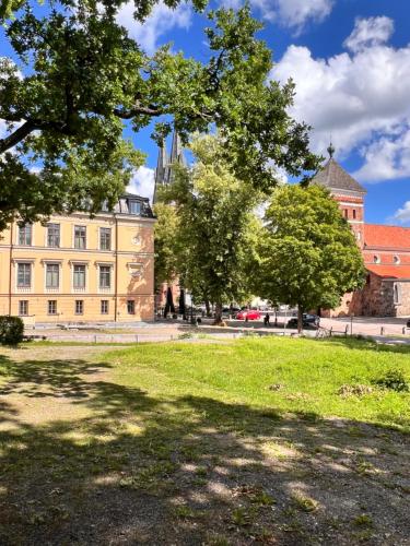 a park with trees in front of a building at Akademihotellet in Uppsala