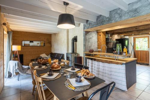 a kitchen and living room with a table and chairs at La Grange de Capucine, gite de caractère in Chainaz-les-Frasses