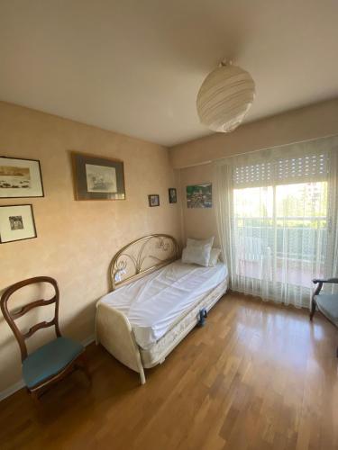 une chambre avec un lit, une chaise et une fenêtre dans l'établissement French Riviera Saint Raphaël Retreat, à Saint-Raphaël