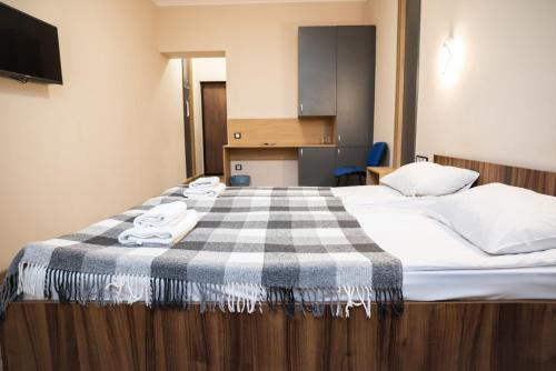 a bedroom with a bed with a checkered blanket on it at RIVER SIDE in Polyana