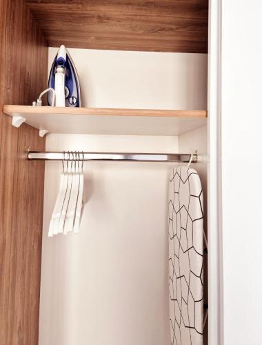 a closet with wooden shelves and a towel at Cinque Stelle Hotel Apartments in Cluj-Napoca
