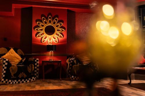 a living room with two chairs and a red wall at The Lansdowne, Eastbourne in Eastbourne