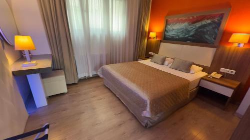 a hotel room with a large bed and a desk at Hotel Baylan İzmir in Izmir