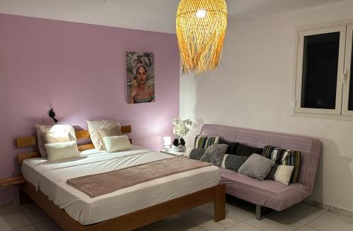 a bedroom with a large bed and a couch at VILLA 3 GRANDE CHAMBRES 4 étoiles in Sainte-Anne