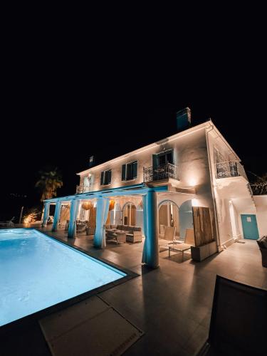 a large white building with a swimming pool at night at Luxury Apartments La Villa in Chorto