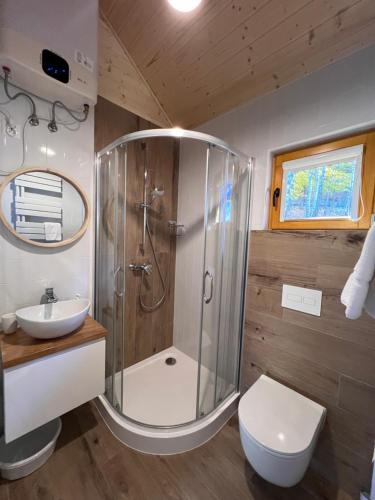 Un baño con ducha, inodoro y lavabo. en Domki Habzówka, en Ostre