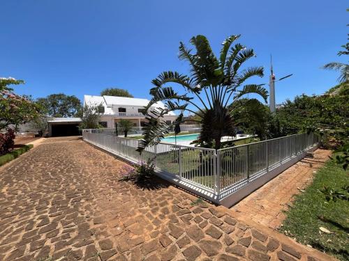 a fence with a palm tree next to a pool at Villa SAIDIA climatisée avec PISCINE in Diego Suarez