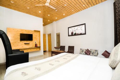 a bedroom with a large bed and a tv at The Bunksters Mcleodganj, Dharmkot in McLeod Ganj