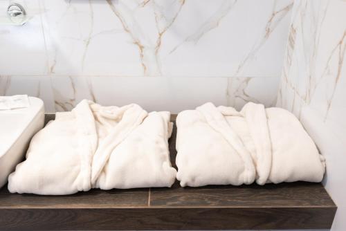 two white towels sitting on a wooden shelf in a bathroom at RIVER SIDE in Polyana
