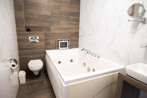 a bathroom with a tub and a toilet and a sink at RIVER SIDE in Polyana