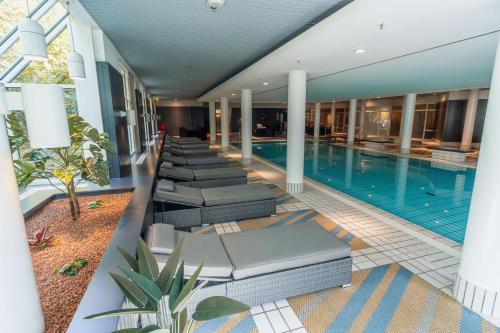 a swimming pool with lounge chairs in a hotel at Radisson Blu Hotel Dortmund in Dortmund